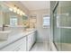 Bright bathroom with double sinks, modern fixtures, and a glass-enclosed shower at 18846 Tracer Dr, Lutz, FL 33549
