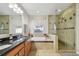 Bathroom featuring double sinks, separate shower, and luxurious tub with tile surround at 18846 Tracer Dr, Lutz, FL 33549