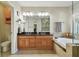 Bathroom with double sinks, separate shower, tub, dark granite countertop and tiled floor at 18846 Tracer Dr, Lutz, FL 33549