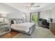 Bedroom with a large window, ceiling fan, wood floor, work space and neutral wall colors at 18846 Tracer Dr, Lutz, FL 33549