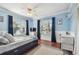 Bright bedroom with blue walls, hardwood floors, white trim, closet and natural light at 18846 Tracer Dr, Lutz, FL 33549