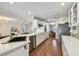 Bright kitchen featuring white cabinetry, quartz countertops, stainless steel appliances, and a view of the living room at 18846 Tracer Dr, Lutz, FL 33549