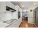 Clean kitchen with white cabinetry, stainless steel appliances, hardwood floors, and stove top at 18846 Tracer Dr, Lutz, FL 33549