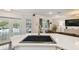Island sink and countertops, a view of the living room and exterior pool at 18846 Tracer Dr, Lutz, FL 33549