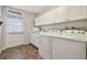 Laundry room featuring a washer, dryer, cabinets, utility sink and access to the backyard at 18846 Tracer Dr, Lutz, FL 33549
