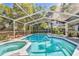 A spacious screened-in pool and jacuzzi offers a private outdoor oasis for relaxation and recreation at 18846 Tracer Dr, Lutz, FL 33549