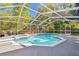 Screened-in pool area featuring a large pool and jacuzzi, perfect for relaxing and entertaining outdoors at 18846 Tracer Dr, Lutz, FL 33549