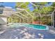 Backyard pool with screened-in enclosure, patio area, and surrounded by lush greenery at 18846 Tracer Dr, Lutz, FL 33549