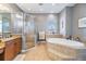 Bathroom with a luxurious soaking tub and a glass-enclosed shower, complete with tile surround at 254 Seagate Ct, Dunedin, FL 34698