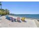Scenic beachfront with colorful chairs, a pier, and serene water views for a relaxing atmosphere at 254 Seagate Ct, Dunedin, FL 34698