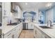 Gourmet kitchen features white cabinets, stainless appliances, and mosaic tile backsplash at 254 Seagate Ct, Dunedin, FL 34698