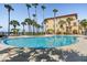 Beautiful community pool with views of the ocean, surrounded by palm trees and lounge chairs at 254 Seagate Ct, Dunedin, FL 34698