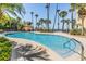 Inviting community pool area with palm trees and clear blue water perfect for relaxation at 254 Seagate Ct, Dunedin, FL 34698