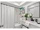 Bright bathroom featuring a shower-tub combo, decorative shelving and a white vanity at 2650 Countryside Blvd # B102, Clearwater, FL 33761