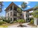 Multi-level condo building showcasing manicured landscaping, tropical palm trees and neutral exterior paint at 2650 Countryside Blvd # B102, Clearwater, FL 33761