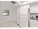Bright kitchen featuring tile flooring and white appliances at 2650 Countryside Blvd # B102, Clearwater, FL 33761