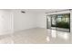 Living room featuring tile flooring, a sliding glass door with a view, and neutral walls at 2650 Countryside Blvd # B102, Clearwater, FL 33761