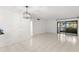 Spacious living room with tile flooring, sliding glass door, and modern light fixture at 2650 Countryside Blvd # B102, Clearwater, FL 33761