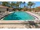 Community pool with lounge chairs and tables surrounded by mature trees at 2650 Countryside Blvd # B102, Clearwater, FL 33761