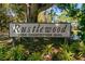 Rustlewood signage with lush landscaping, set against the backdrop of a well-maintained community at 2650 Countryside Blvd # B102, Clearwater, FL 33761