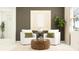 The staged living room has white armchairs, a decorative coffee table, olive-green pillows, and neutral walls with artwork at 31794 Griffin Sands Ln, San Antonio, FL 33576