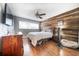 Comfortable bedroom with hardwood floors, a wood accent wall, and ample natural light, creating a cozy retreat at 3219 Spanish Moss Ln, Palm Harbor, FL 34684