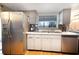 Clean kitchen with stainless steel appliances, white cabinets, and a double basin sink at 3219 Spanish Moss Ln, Palm Harbor, FL 34684