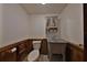 Powder room with gray vanity, toilet, and wood-panelled walls offers a cozy and functional space at 352 Shore E Dr, Oldsmar, FL 34677