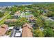 Property aerial view shows tennis courts, mature trees and covered parking at 3632 Pine Cone Cir, Clearwater, FL 33760