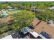 Aerial view of a home surrounded by lush landscaping with tennis courts and a community pool at 3632 Pine Cone Cir, Clearwater, FL 33760