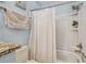 Bathroom featuring a tub with shower and tiled walls and floor at 3632 Pine Cone Cir, Clearwater, FL 33760