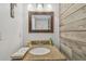 Stylish powder room featuring a wood accent wall, granite countertop, and decorative lighting at 3632 Pine Cone Cir, Clearwater, FL 33760