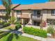 Well-maintained townhouse featuring a charming front yard with mature landscaping and a private balcony at 3632 Pine Cone Cir, Clearwater, FL 33760
