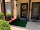 Welcoming front entry featuring decorative wreath, lush greenery, and charming welcome mat at 3632 Pine Cone Cir, Clearwater, FL 33760
