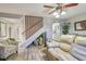 Inviting living room featuring a staircase, ceiling fan, and comfortable seating arrangement at 3632 Pine Cone Cir, Clearwater, FL 33760
