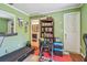 Office featuring green walls, wood floors, and bathroom access at 3632 Pine Cone Cir, Clearwater, FL 33760