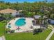 Aerial view of community pool with sun loungers, tables and clubhouse at 3632 Pine Cone Cir, Clearwater, FL 33760