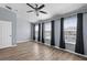 This primary bedroom features light-grey walls, wood floors, and black window curtains at 4081 71St N Ter, Pinellas Park, FL 33781