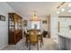 Cozy dining area features carpeted floors, chandelier lighting, and a wooden china cabinet for storage and display at 443 Tuna Ct, Oldsmar, FL 34677