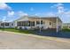 Charming single-story home with carport, screened porch, and well-maintained landscaping under a bright blue sky at 443 Tuna Ct, Oldsmar, FL 34677