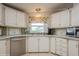 Well-lit kitchen featuring tiled countertops, stainless steel dishwasher, and ample cabinetry for storage at 443 Tuna Ct, Oldsmar, FL 34677