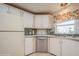 Well-equipped kitchen with stainless steel dishwasher, bright window, and white cabinets offer a functional cooking space at 443 Tuna Ct, Oldsmar, FL 34677