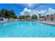 Large community pool with plenty of lounge chairs and lush tropical landscaping at 443 Tuna Ct, Oldsmar, FL 34677