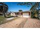 Single-story home with attached garage, driveway, a covered front porch with bench, and mature trees at 4811 Daphne St, New Port Richey, FL 34652