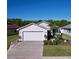 Charming single-story home with well-maintained landscaping and a two-car garage on a sunny day at 6117 Crickethollow Dr, Riverview, FL 33578