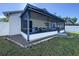 Rear exterior view featuring a screened lanai with outdoor furniture and a well-kept lawn at 6117 Crickethollow Dr, Riverview, FL 33578