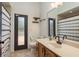 Bathroom features a black framed door, a vanity with a single sink, a mirror, and toilet with striped curtain at 6219 Riviera Ln, New Port Richey, FL 34655