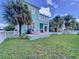 Green backyard featuring a patio with outdoor seating, white fencing, and lush tropical landscaping at 6564 Simone Shores Cir, Apollo Beach, FL 33572