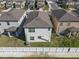 Aerial view of a new home featuring a backyard patio, well maintained lawn and crisp white perimeter fence at 7229 Spring Snowflake Ave, Tampa, FL 33619