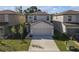 Aerial view of a two-story home with a two-car garage, driveway, and lawn at 7229 Spring Snowflake Ave, Tampa, FL 33619